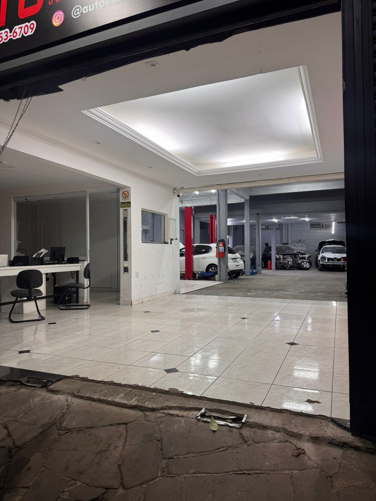 Interior da oficina Auto Excellence com elevadores e veículos em manutenção